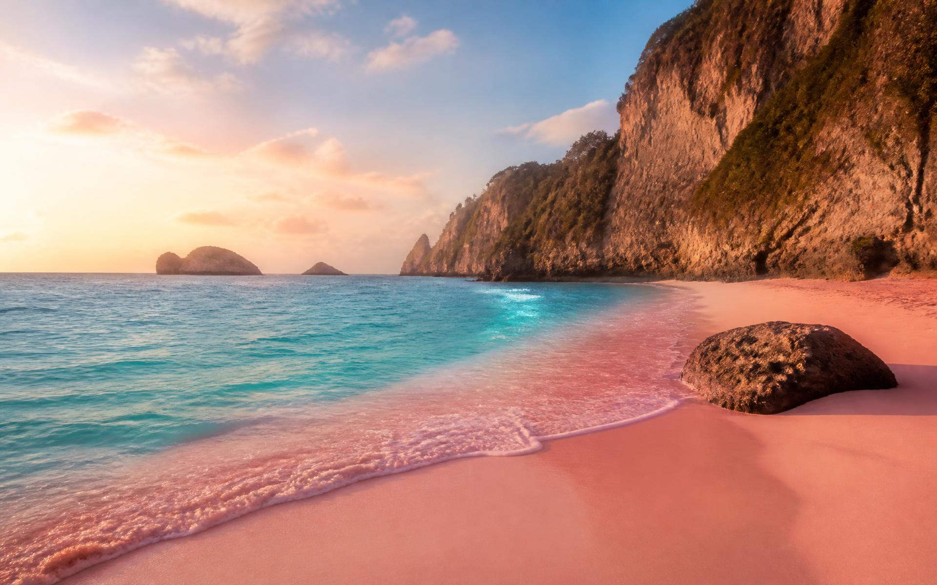 Turquoise ocean meeting a pink sand beach at golden hour